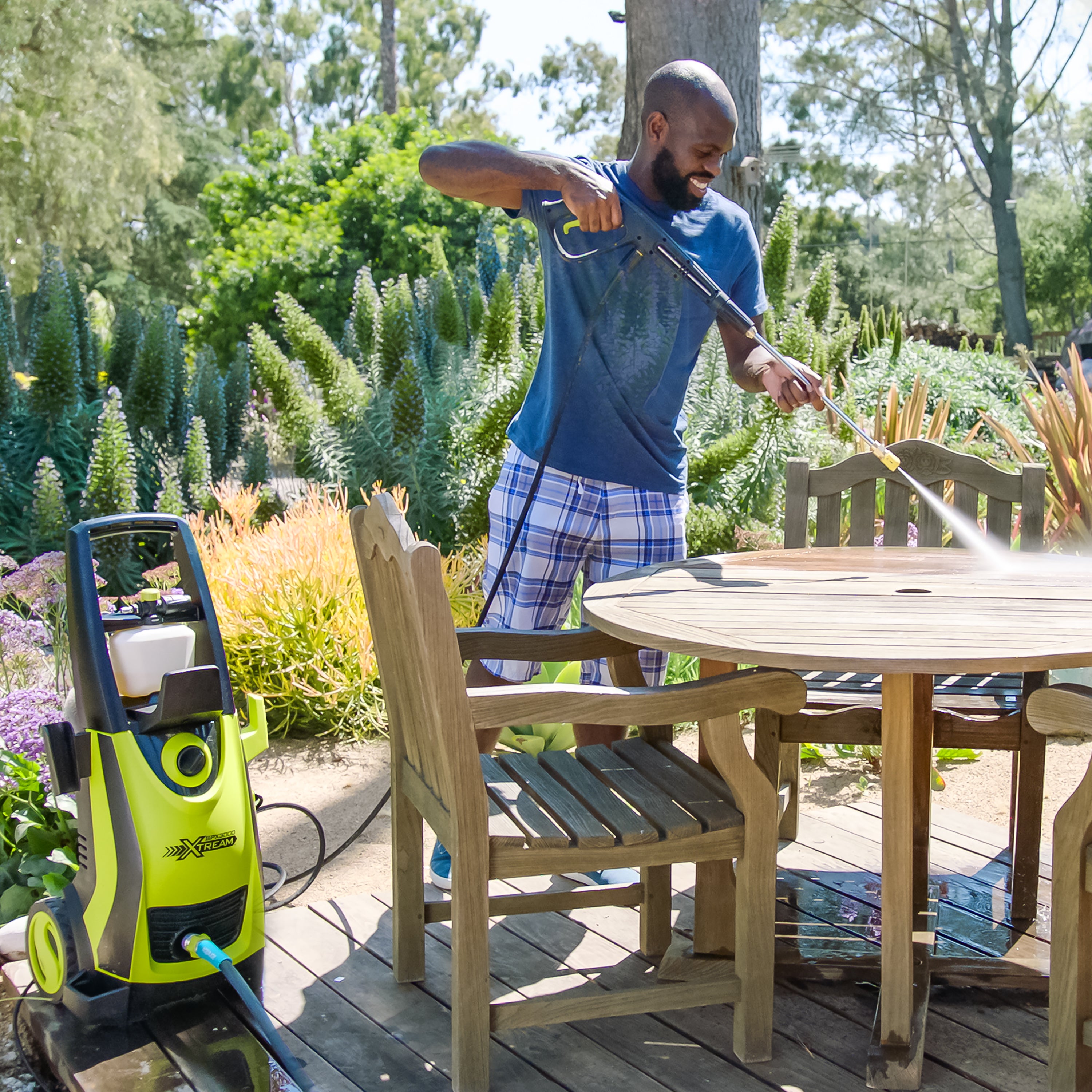 Sun Joe 13-amp 2200 PSI Extreme Clean Electric Pressure Washer being used to clean patio furniture.