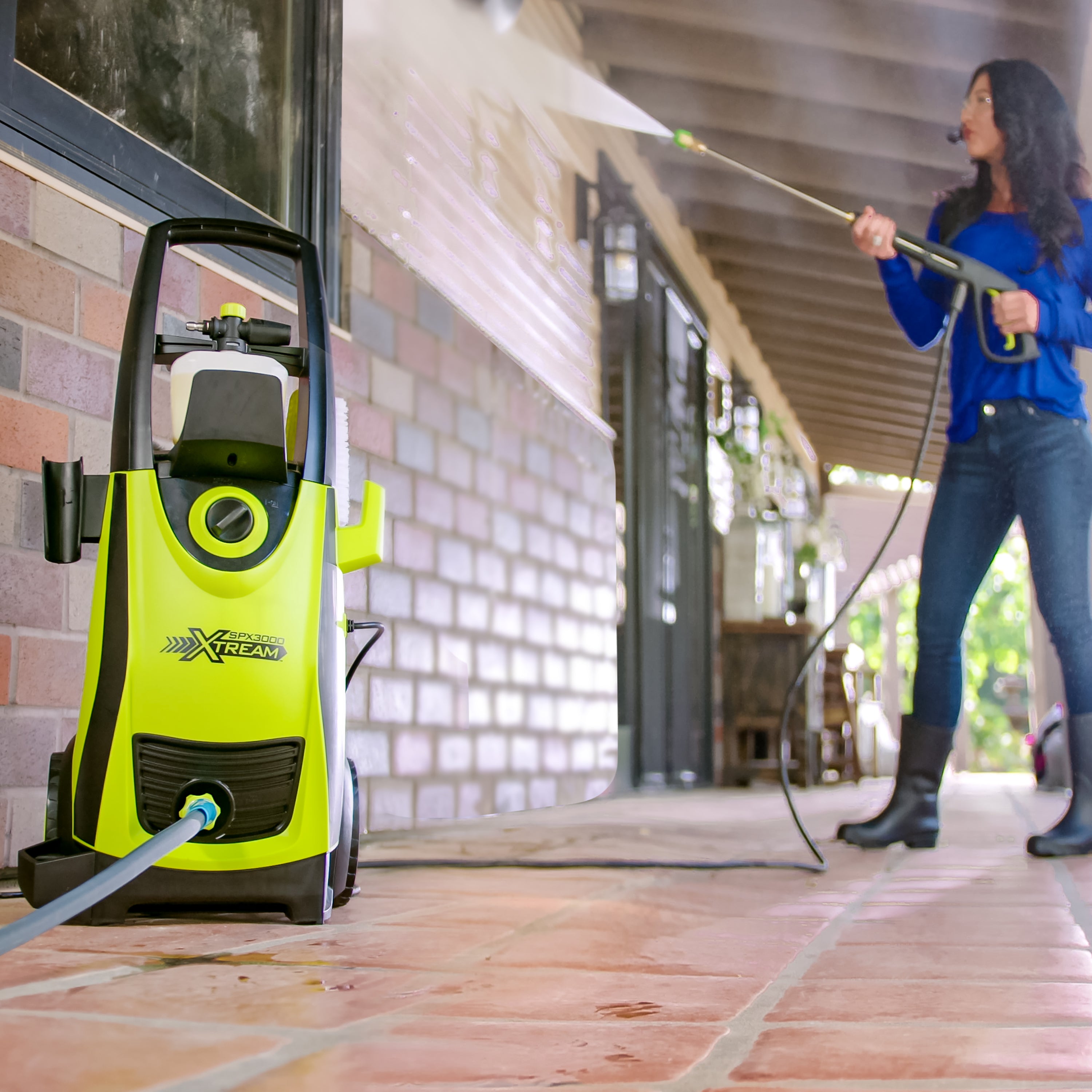 Sun Joe 13-amp 2200 PSI Extreme Clean Electric Pressure Washer being used to clean a brick wall.