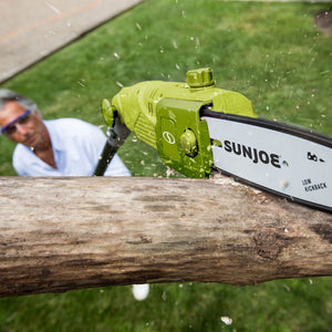 Sun Joe 6.5-amp 8-inch Electric Multi-Angle Pole Chain Saw cutting a tree limb.